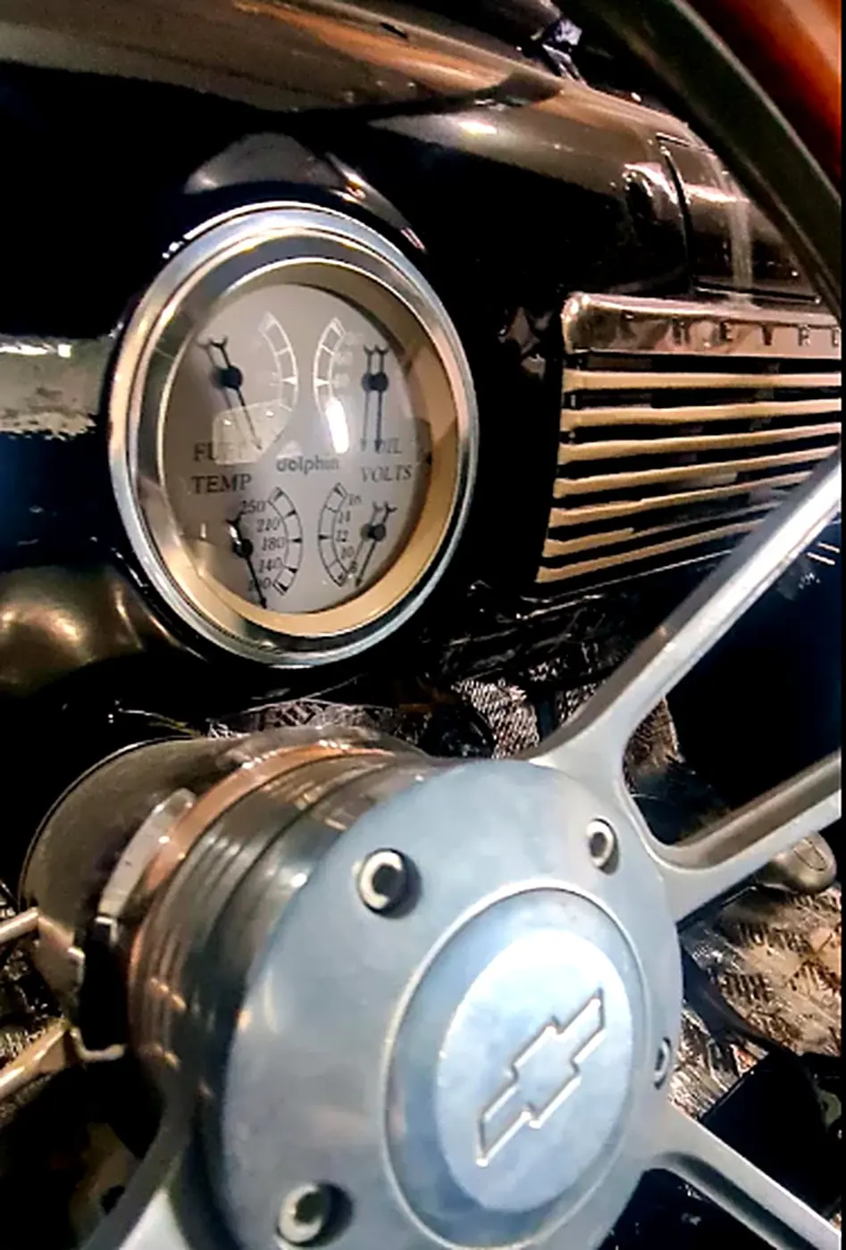 Close-up of a classic Chevrolet gauge and steering wheel