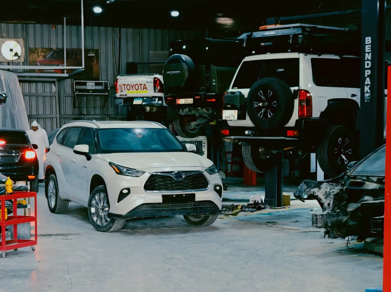 Toyota Hybrid, Nissan Patrol, and Land Rover Defender receiving periodic maintenance and mechanical service at M19 Car Service Center in Musaffah M38 Abu Dhabi