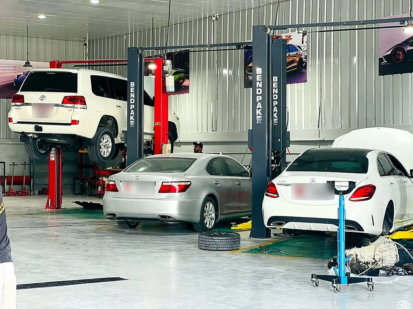 Land Cruiser raised on a red two-post lift in the M19 mechanical bay